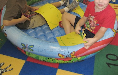 two preschoolers practicing cutting and fine motor control in a pool