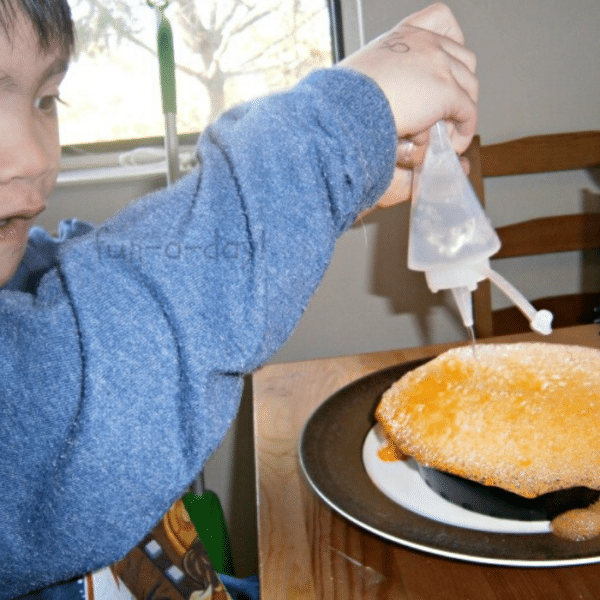 child squeezing vinegar on baking soda and jello