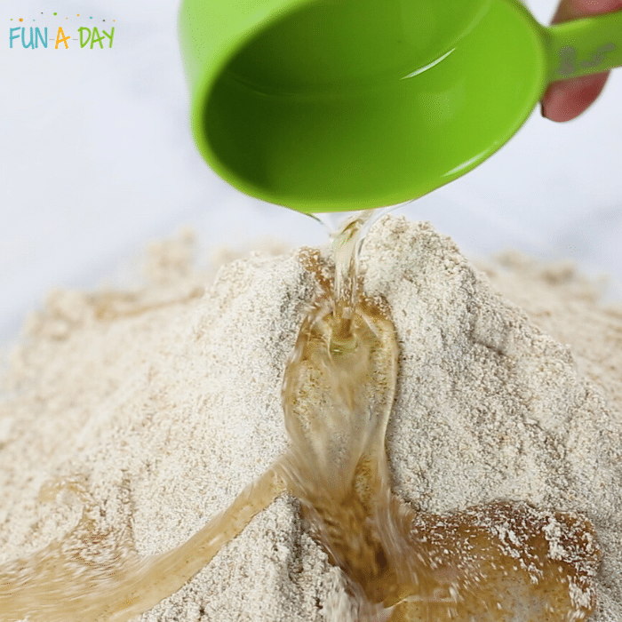 pouring oil on flour to make taste safe play sand