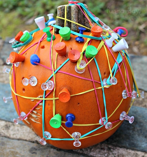 Geoboard pumpkin covered in golf tees, push pins, and rubber bands