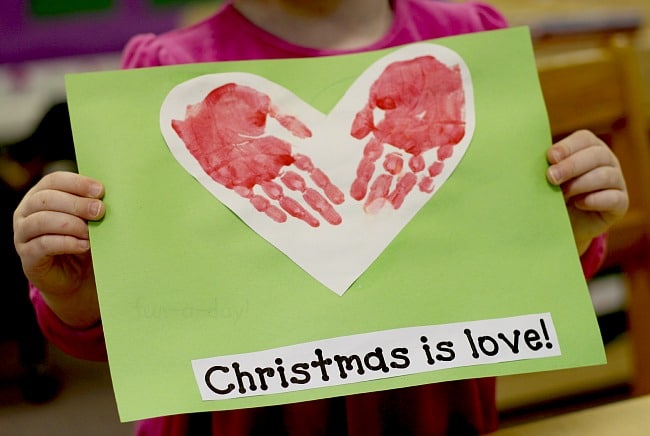 child-made hand print heart with text that reads christmas is love