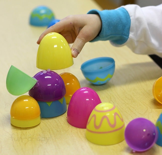child using plastic Easter eggs to make a sculpture