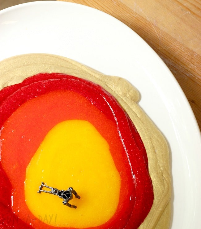 gold slime, red slime, orange slime, and yellow slime on a white platter with a LEGO droid