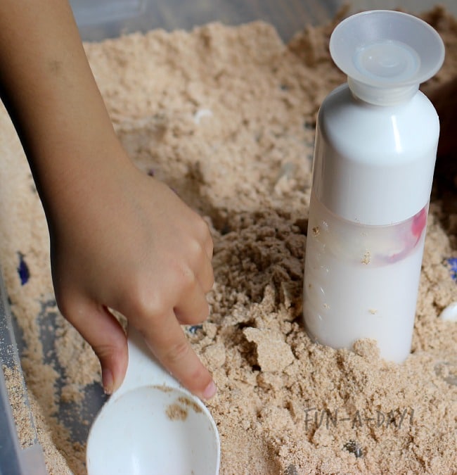 setting up a fun science activity with play sand
