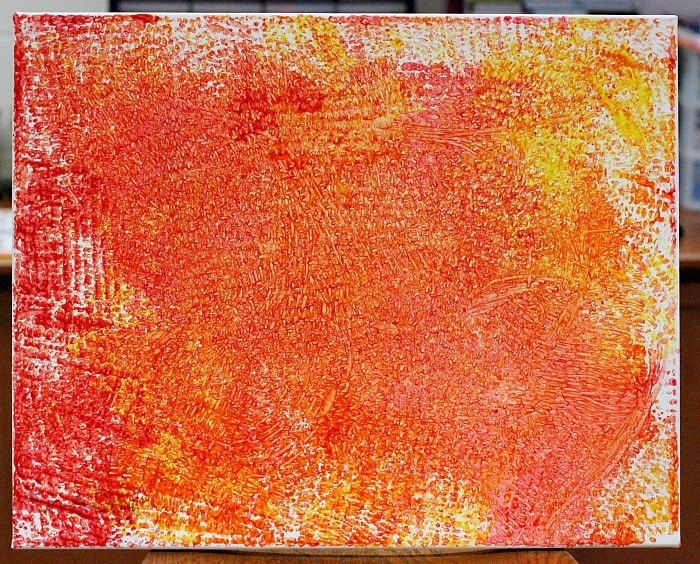 preschool collaborative process art canvas in red, yellow, and orange paint