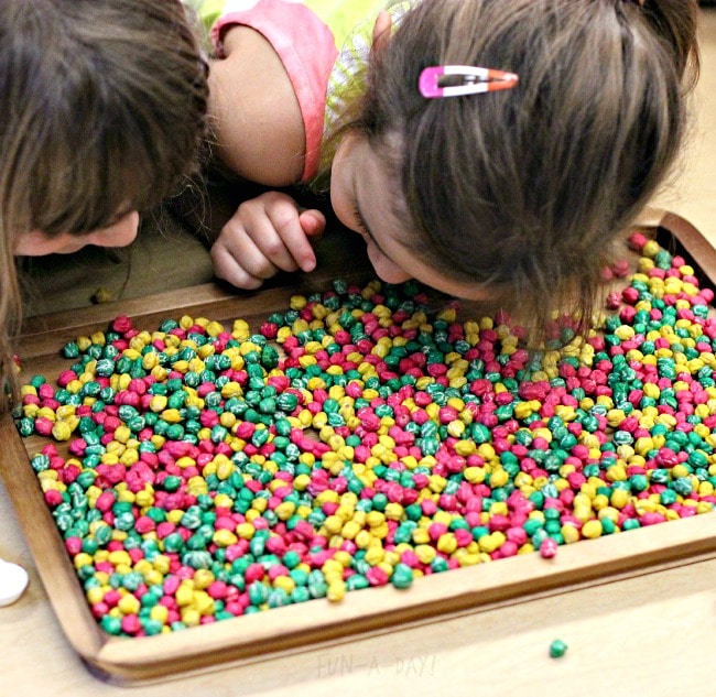 preschoolers observing apple sensory bin materials with their senses