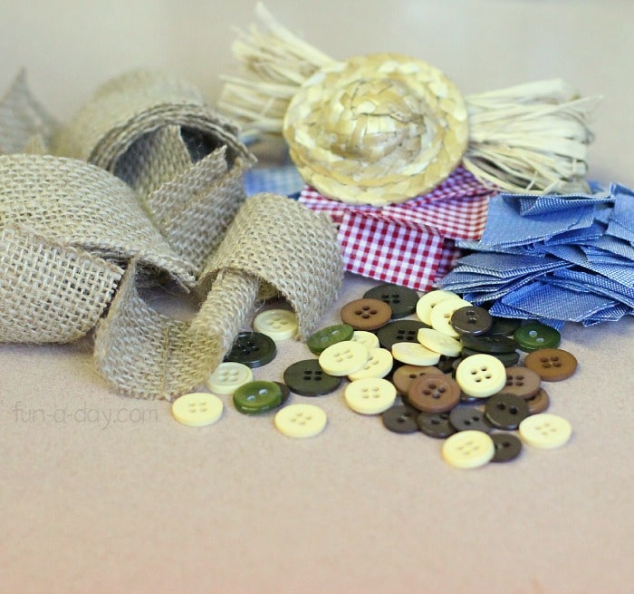 Scarecrow art materials - burlap, buttons, hay, fabric, and buttons.