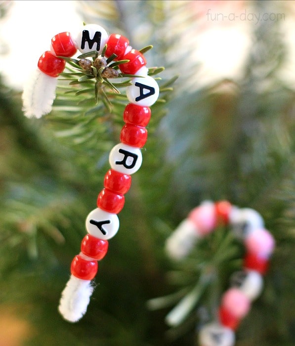 a candy cane name ornament with two red beads patterened in between white beads that spell out the name Mary