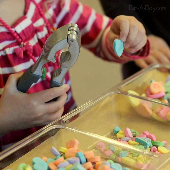 child using a nutcracker to break candy hearts