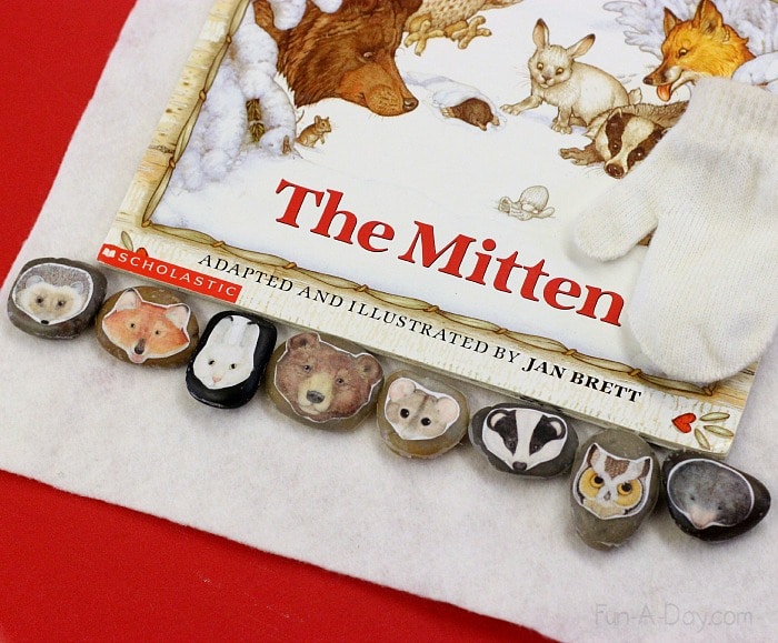 The Mitten book with homemade story stones and small white mitten