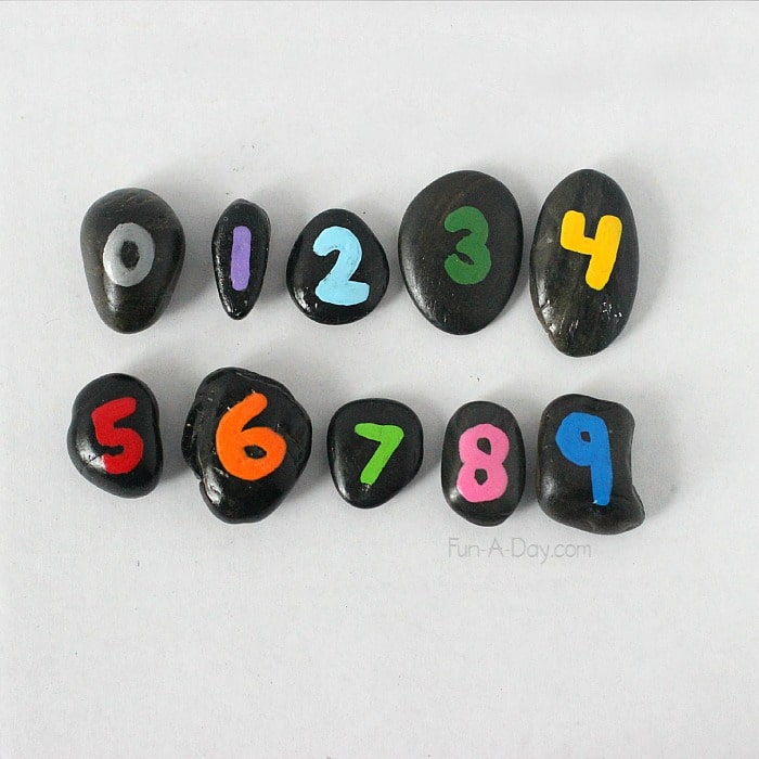black rocks with the numbers zero to nine painted on them, one number per rock