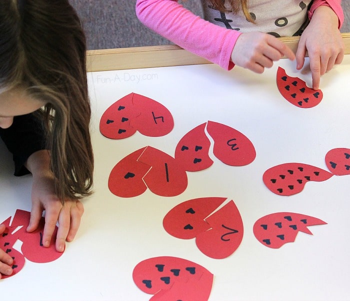 Working together on Broken Heart Numbers - a fun preschool valentine math activity that teaches important early math concepts
