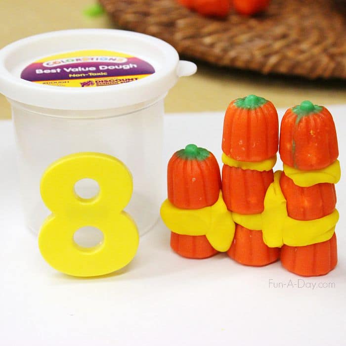 magnetic number 8 and eight candy pumpkins built with play dough