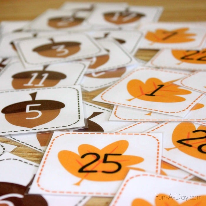 Printable leaf and acorn number cards spread out on a table.