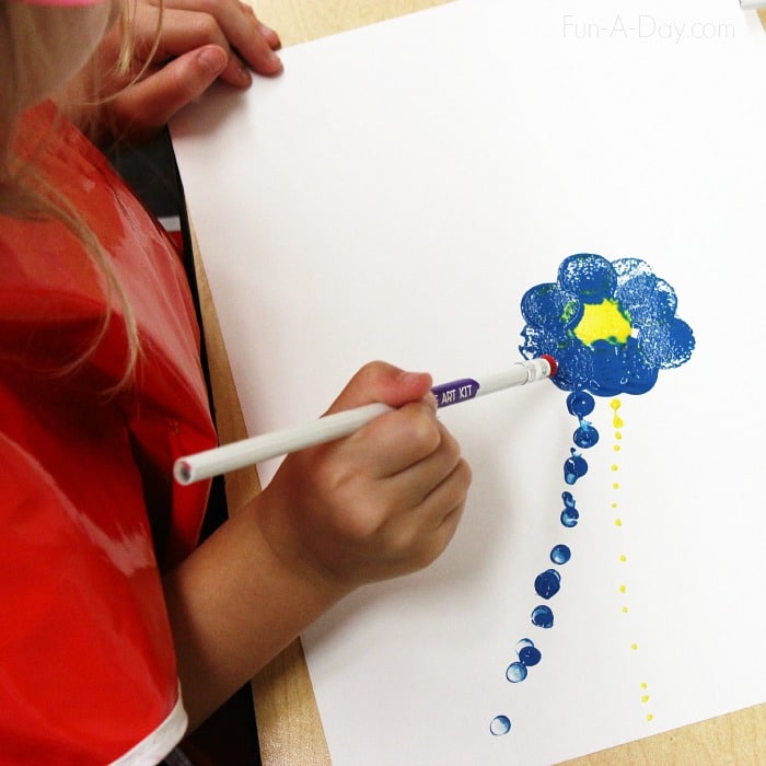 child using an eraser dipped in paint to create a flower