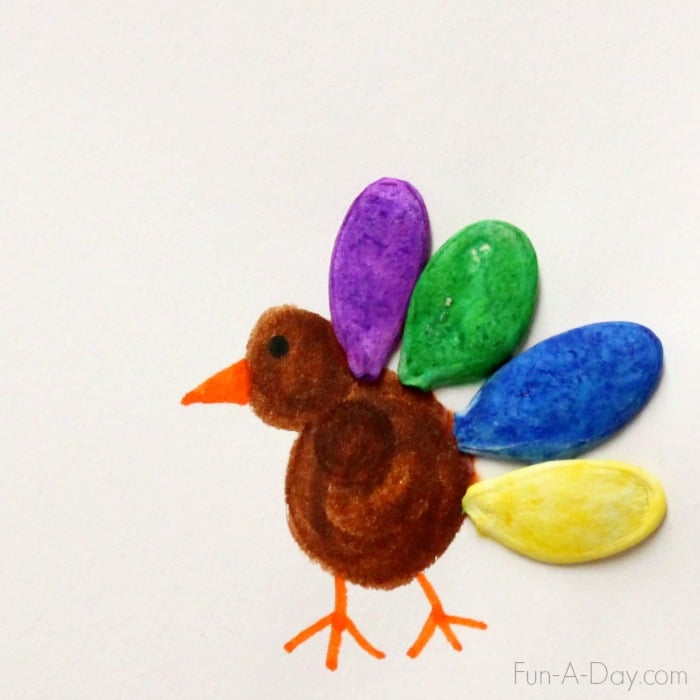 Thanksgiving art for kids using colorful pumpkin seeds