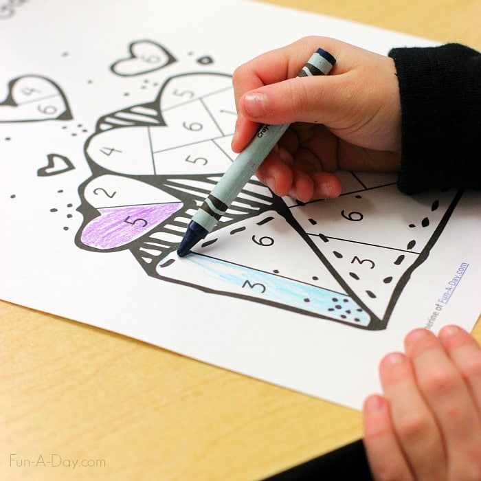 Preschool child coloring in a free printable valentine dice game