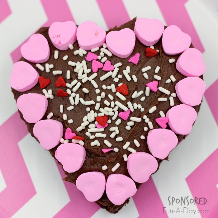 a frosted brownie for a you've been hugged surprise sitting on a pink and white background