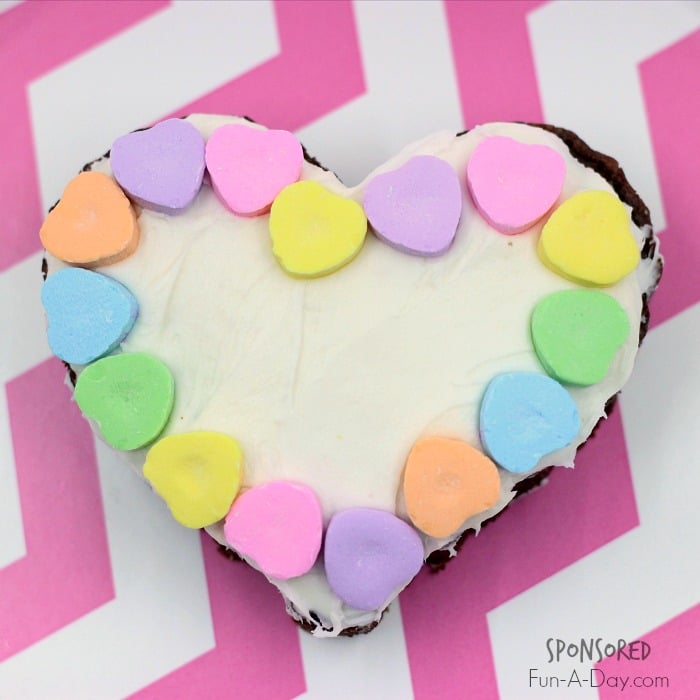 a frosted brownie with a conversation heart border for a Valentine's Day version of you've been booed sitting on a pink and white background