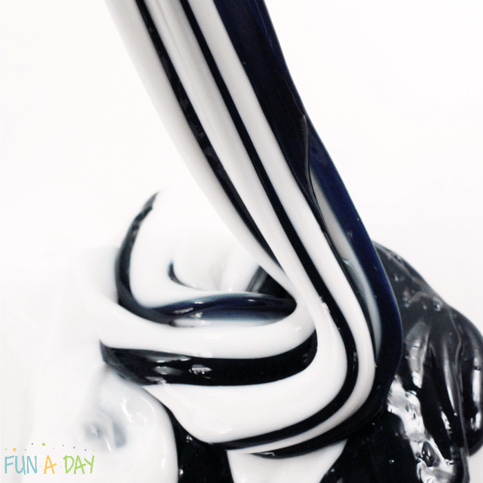 A swirl of striped white and black slime pooling onto a table