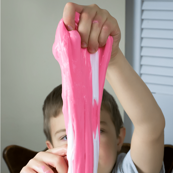 Child stretching candy cane slime.