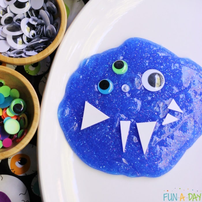 blue glitter slime with googly eyes and foam triangles