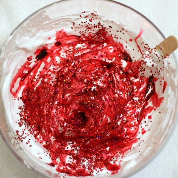 Adding color and glitter to candy cane shaving cream slime