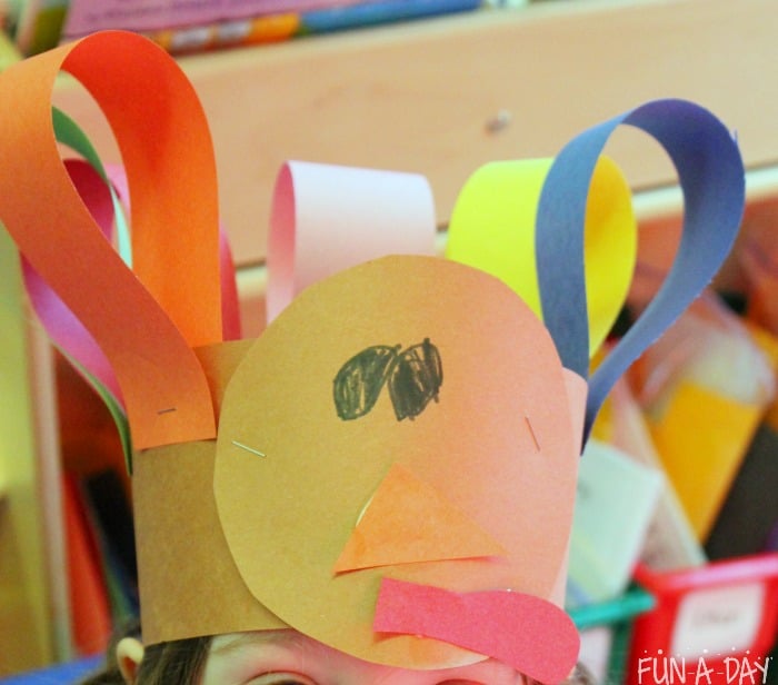Preschooler wearing turkey hat craft.