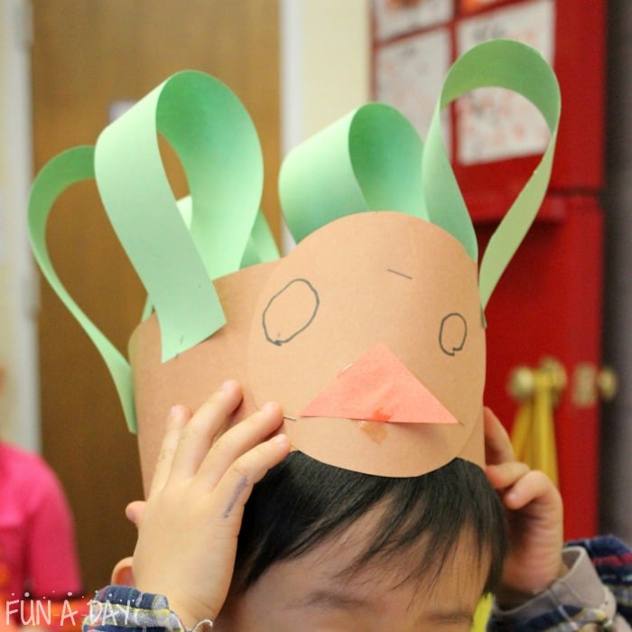 Child made turkey hat craft green feathers.
