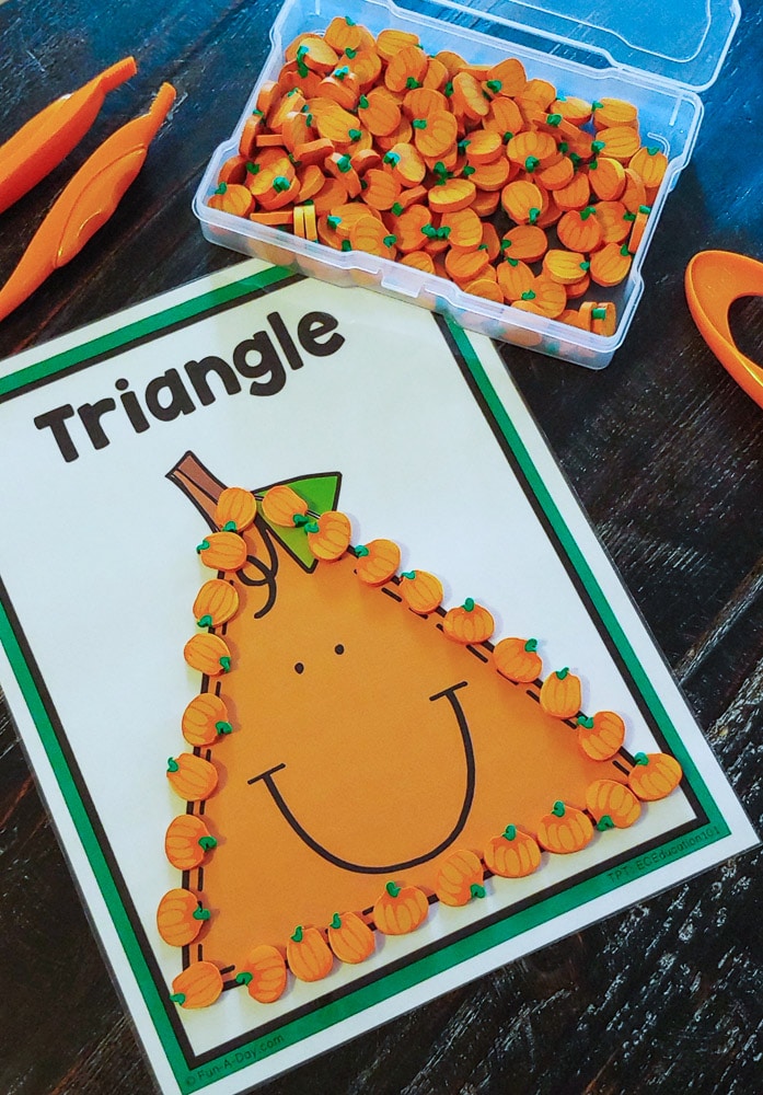 printable triangle pumpkin shape mat with tiny pumpkin erasers forming the triangle