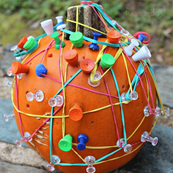 geoboard pumpkin with pins and golf tees in it and rubber bands wrapped around the tees and pins