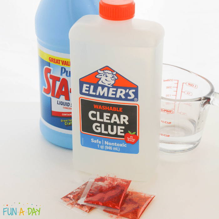 Sta-Flo liquid starch, Elmer's washable clear glue, measuring cup, packets of glitter in red, orange, and brown.