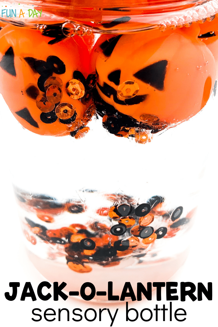 Clear bottle with orange and black sequins and small plastic jack-o-lanterns floating in a clear liquid; text that reads 