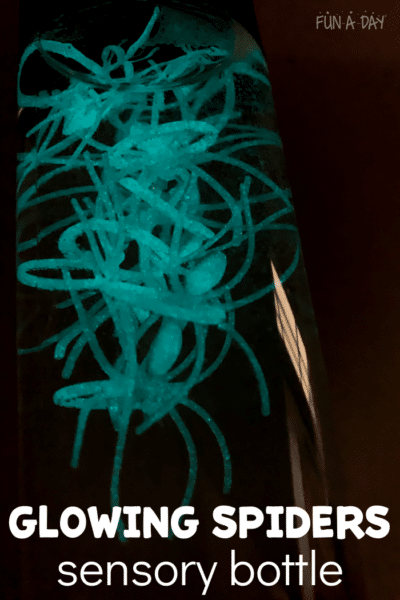 Glow in the dark spider sensory bottle glowing mint green color in a dark room.