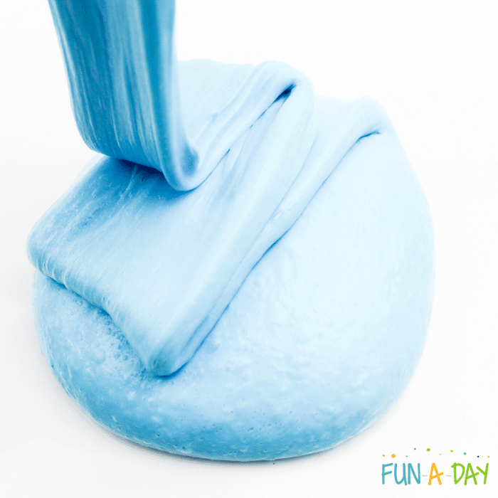 Icy blue slime being stretched and dropped onto white background.