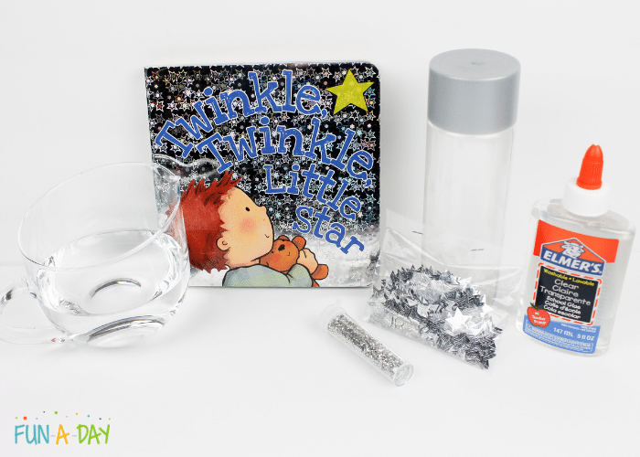 Materials needed to make the star sensory bottle which include cup of water, silver glitter, silver star confetti, clear bottle, clear Elmer's glue, and Twinkle, Twinkle, Little Star book.