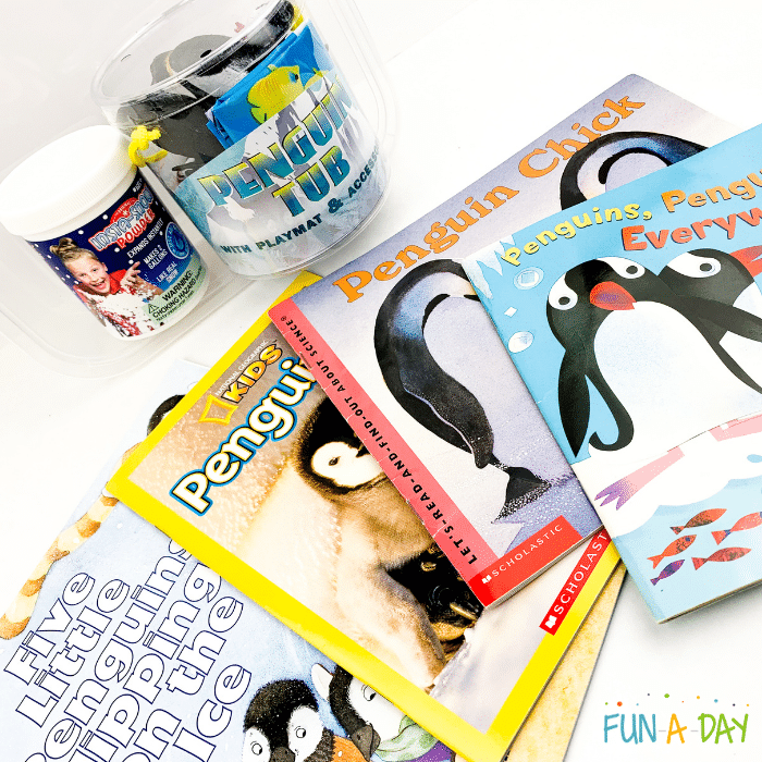 Sensory bin materials and penguin-themed books.
