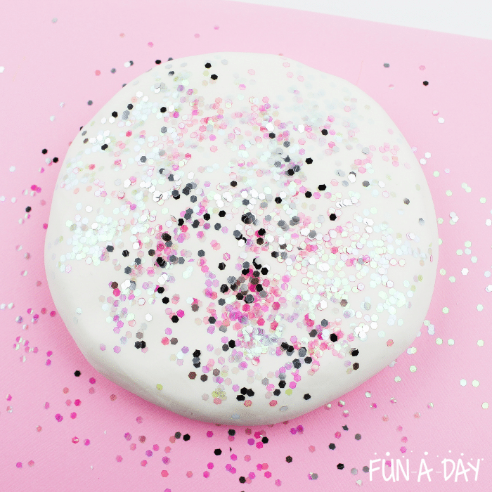 Glitter poured on top of a ball of white play dough.