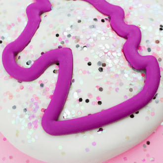Unicorn cookie cutter in unicorn dough with text that reads unicorn cornstarch play dough.