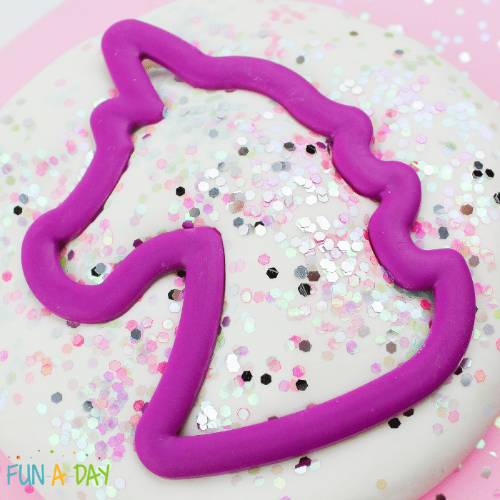 Unicorn cookie cutter stamped into unicorn play dough.
