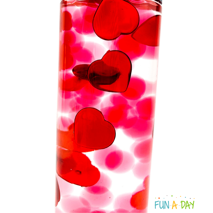 Valentine sensory bin with acrylic hearts along with red and clear water beads.