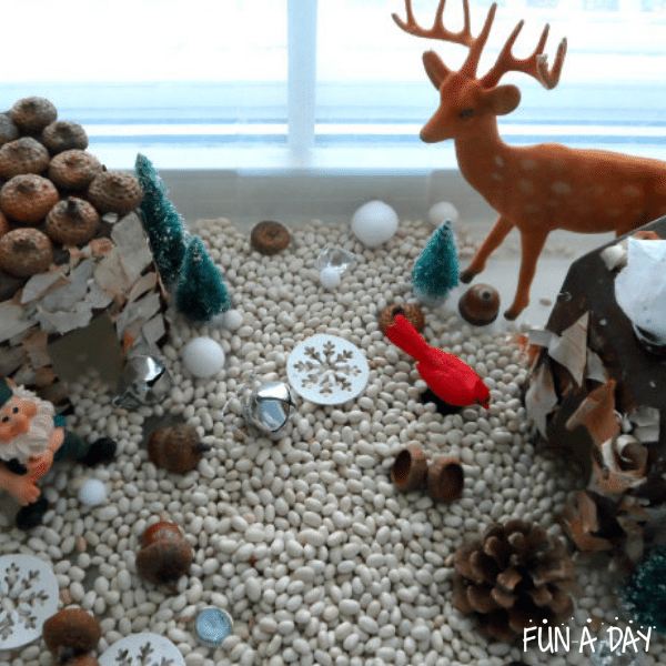 Winter small world with white beans, natural materials, and forest toys