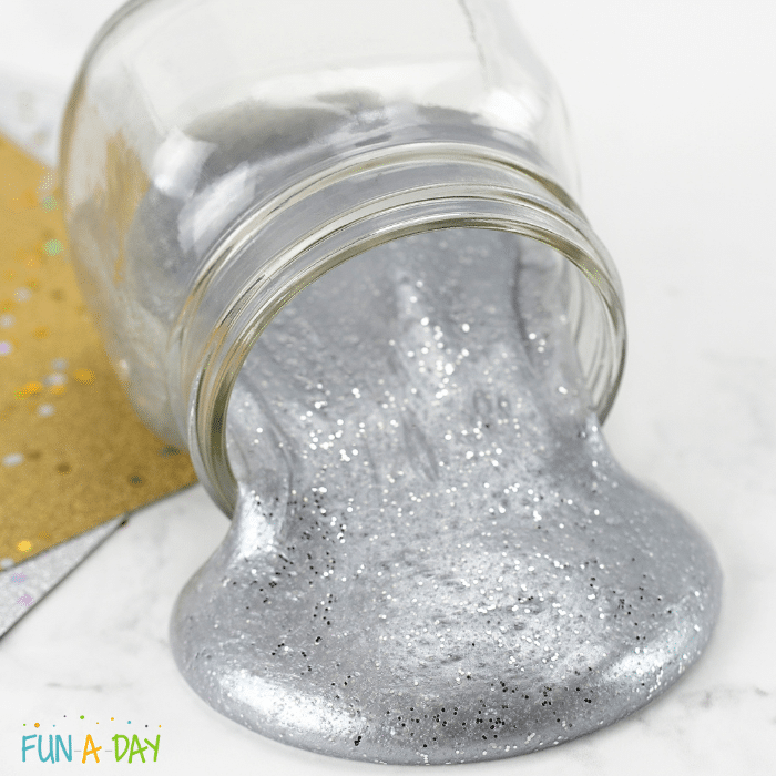 Small clear jar pouring out silver slime.