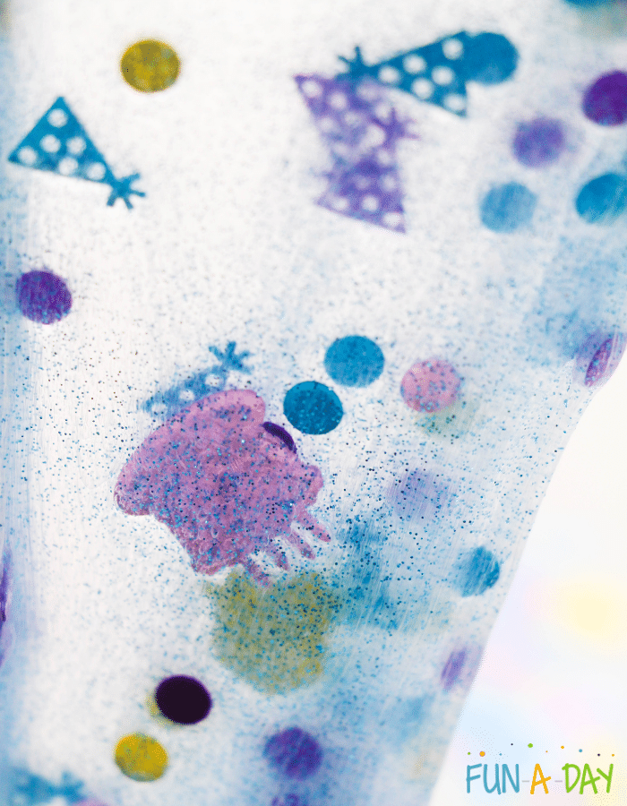 Close-up of translucent slime with blue glitter and birthday confetti.