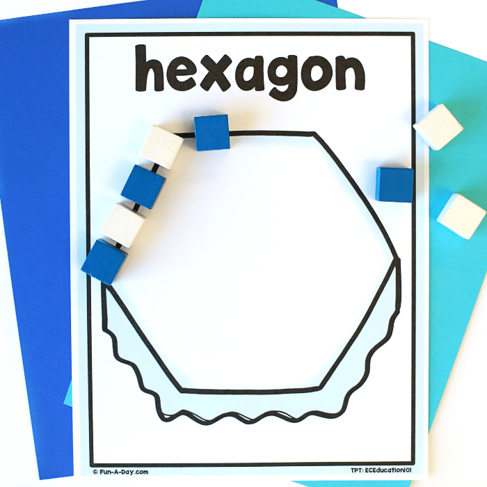 Lining up blue and white blocks around the perimeter of the hexagon iceberg printable.