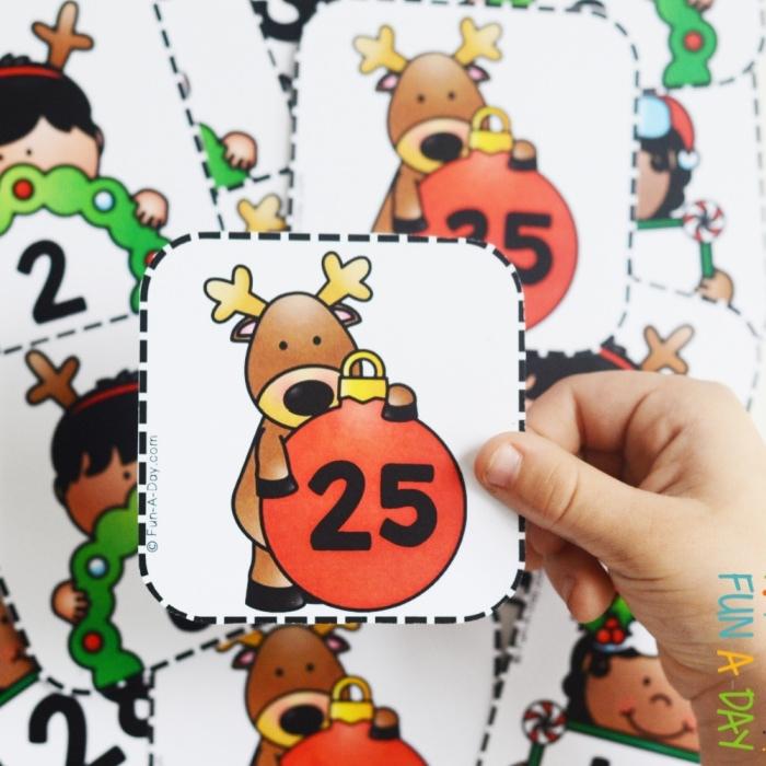 child's hand holding a christmas number card from a preschool counting activity