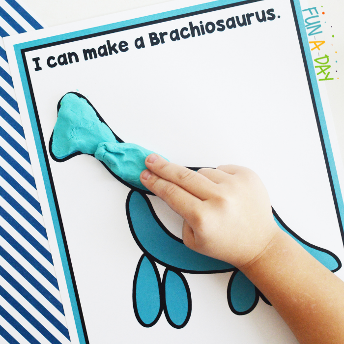 Person using play dough to make the shape of a brachiosaurus on the free printable mat.
