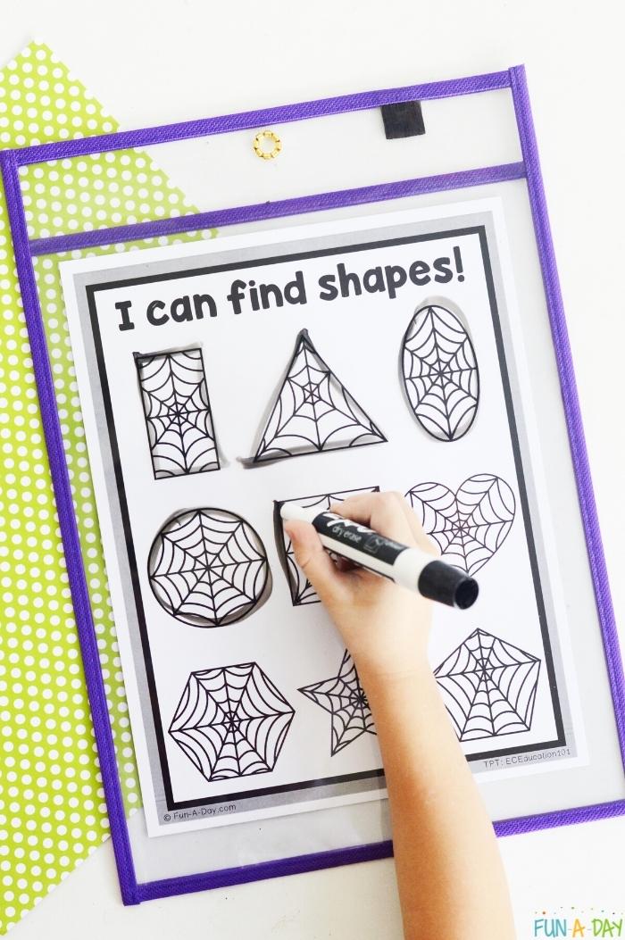 child's hand tracing shapes on spider web shape mats