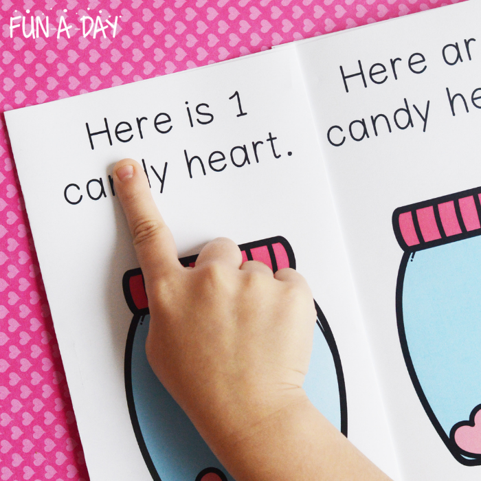 preschooler pointing to words in a counting hearts printable book