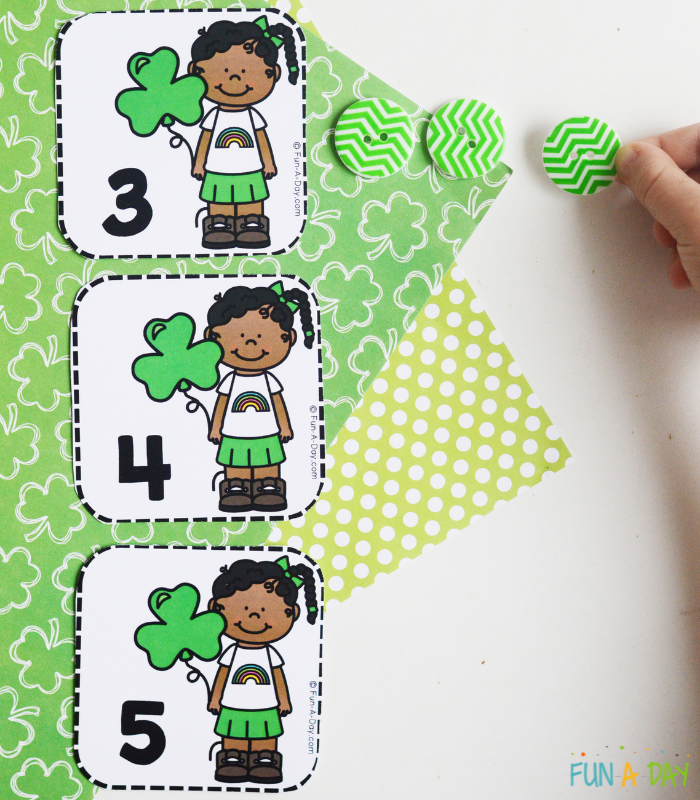 child's hand using buttons to interact with st. patrick's day math printables